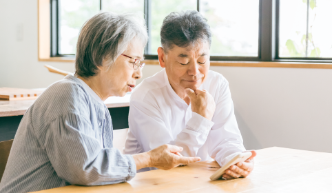 スマートフォンを見ながら相談する夫婦